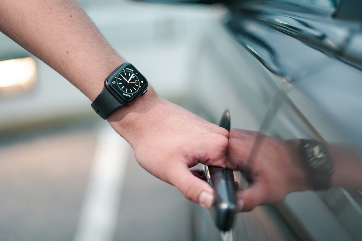 A hand opening a car door handle