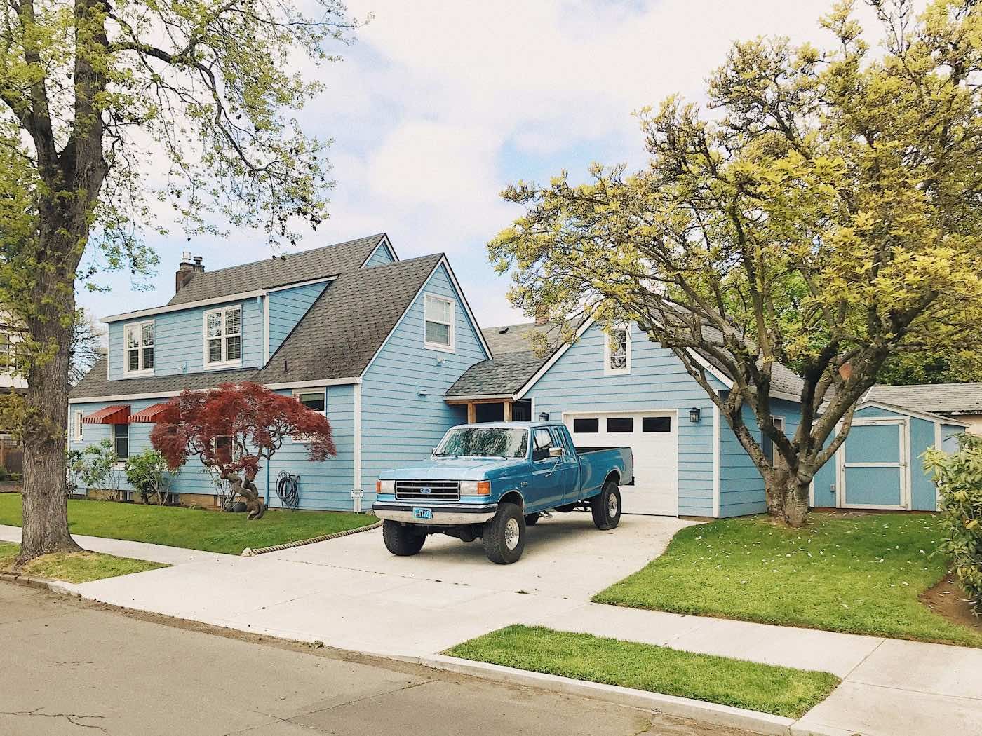 A pickup truck parked in the driveway of a house