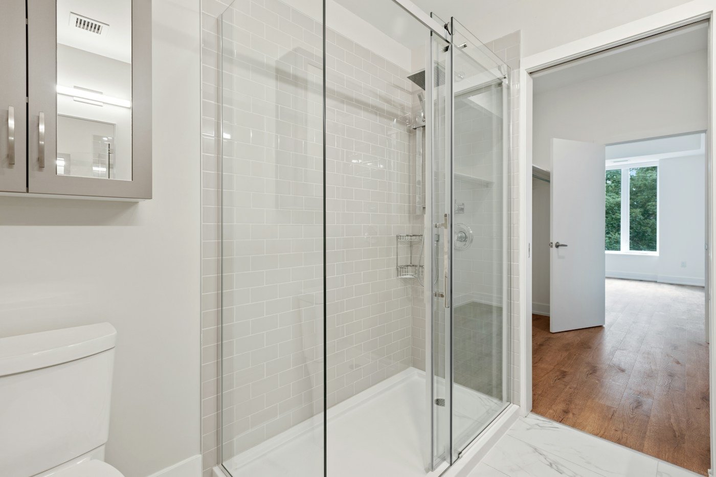 A finished walk in glass shower with subway tile