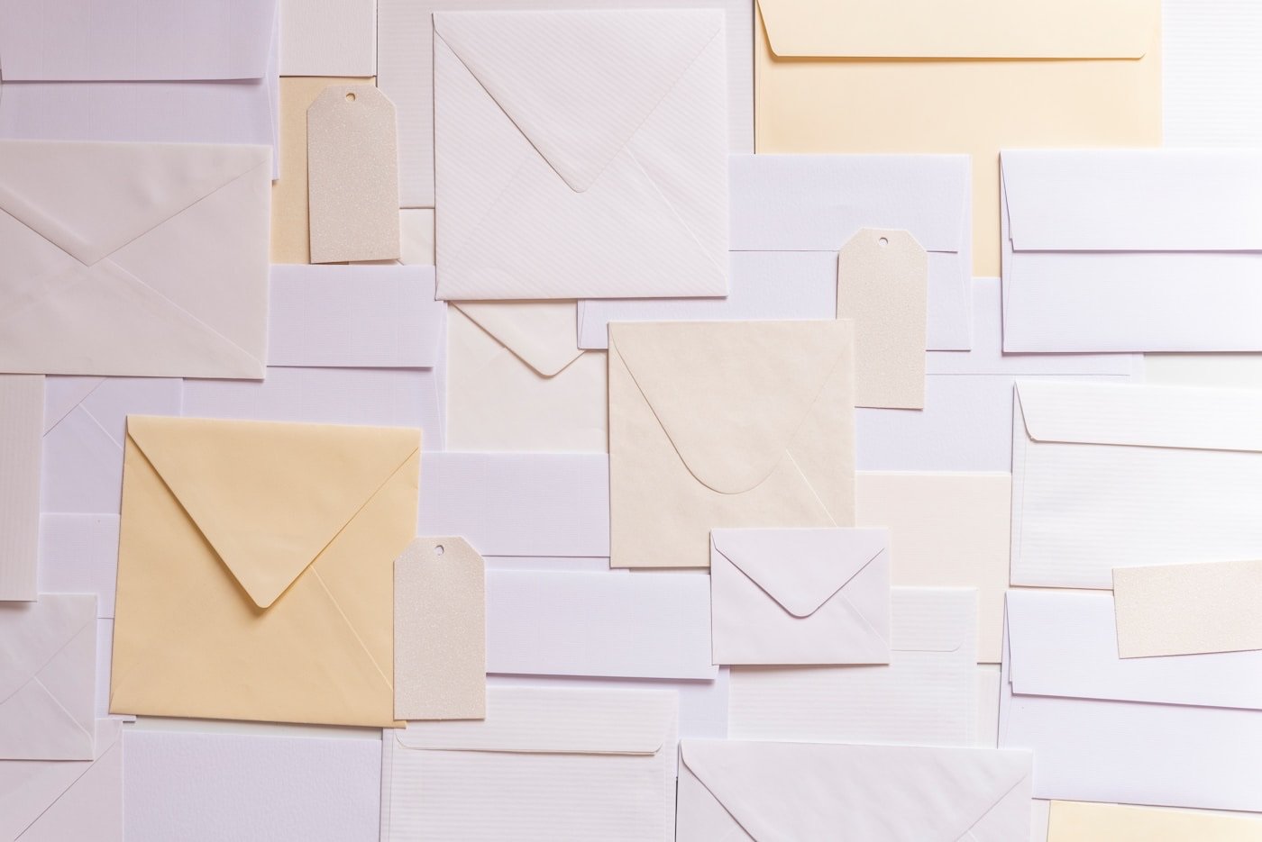 A stack of plain envelopes in cream and pale colors