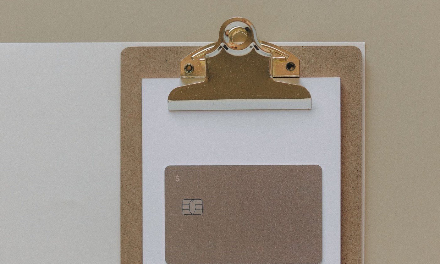 A blank bank card clipped to a clipboard, no numbers visible