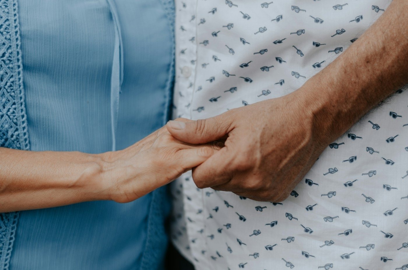 Two people's hands clasped together, faces not shown