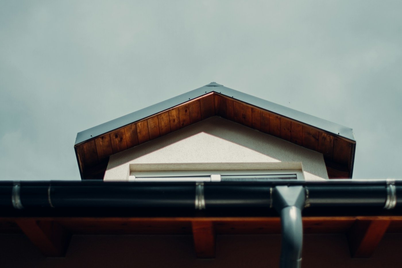 A house gable with wood eaves and a gutter and downspout